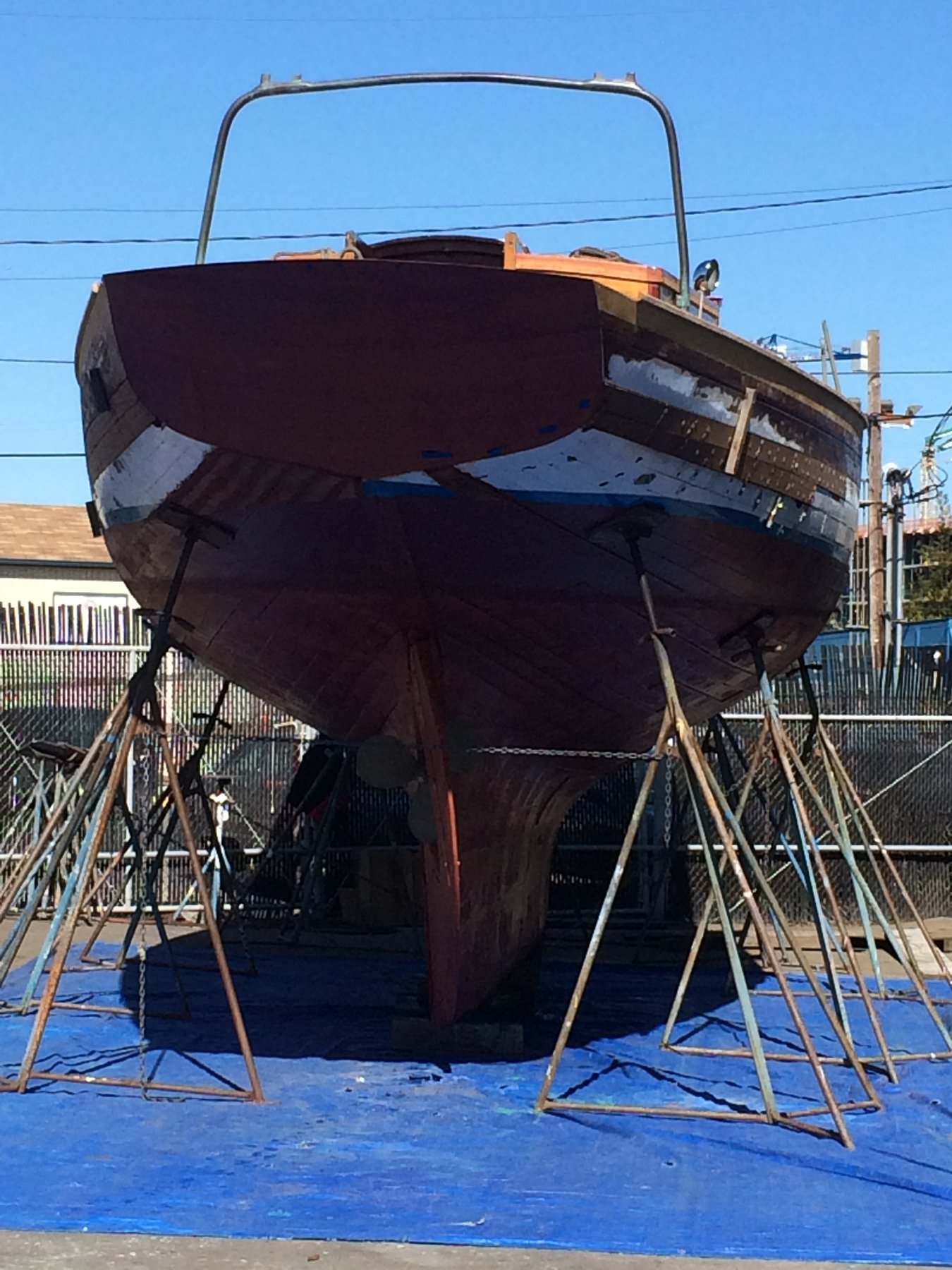 The classic 1946 Philip Rhodes-designed Merry Maiden rests on the hard in Puget Sound, her dark hull and graceful lines evident even out of the water, awaiting maintenance or restoration.