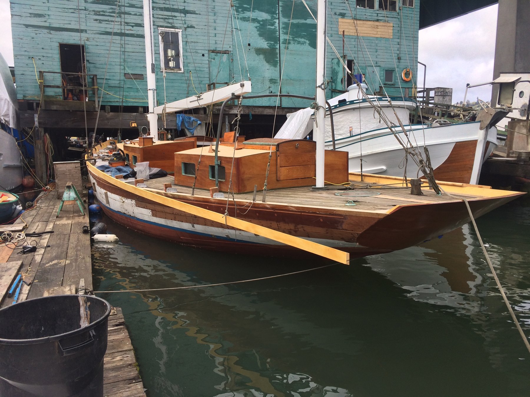 The classic 1946 Philip Rhodes-designed Merry Maiden rests peacefully at her moorings in Puget Sound, her warm wooden hull and traditional lines a testament to mid-century craftsmanship and timeless maritime design.