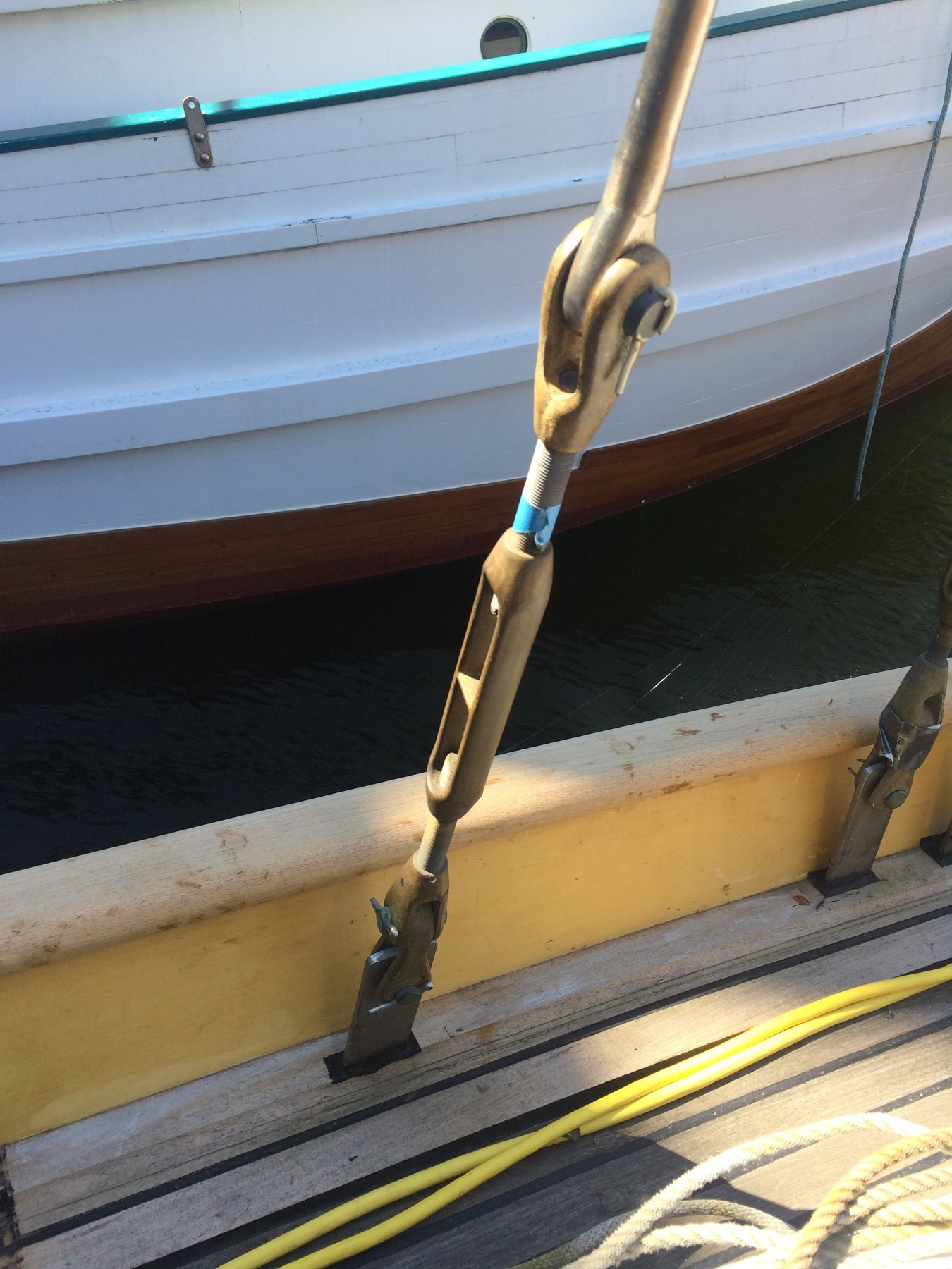 A bronze boom vang and fittings gleam in the spring sunlight on the classic 1946 Philip Rhodes yacht Merry Maiden, her weathered hull and vintage hardware speaking to decades of Puget Sound sailing.