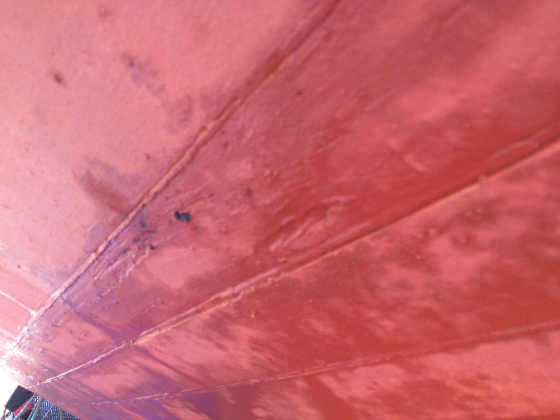 The faded red mainsail of the classic Merry Maiden catches the spring light, revealing the patina and character of this 1946 Philip Rhodes design in the calm waters of Puget Sound.