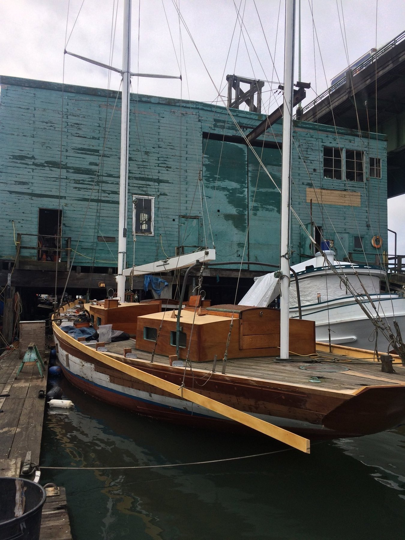 The classic lines of Merry Maiden, a 1946 Philip Rhodes design, rest peacefully at her moorings in Puget Sound, her weathered hull and traditional rigging a testament to decades of Pacific Northwest sailing.