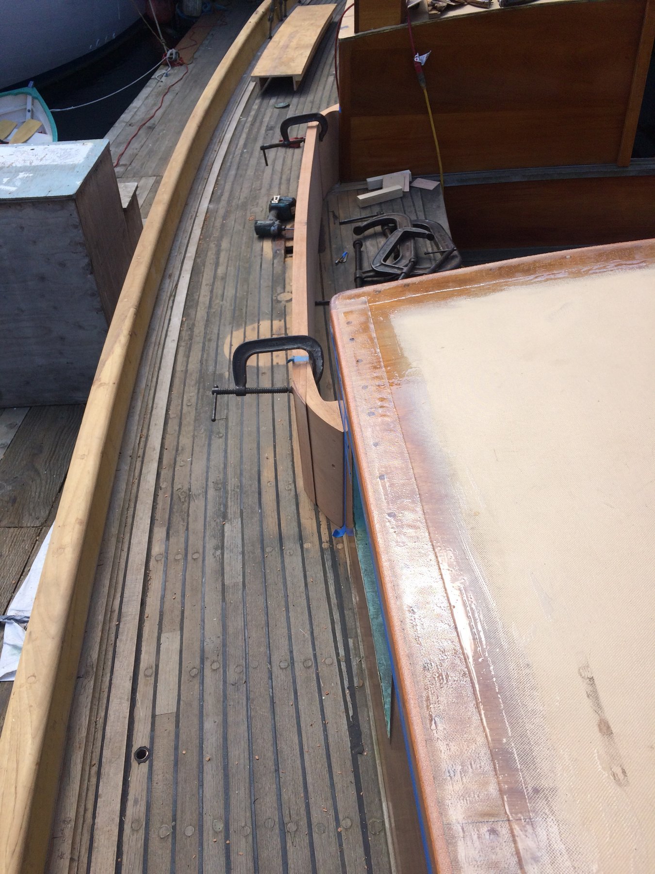 The classic lines of Merry Maiden's cabin trunk and sheer strake reveal meticulous restoration work on this 1946 Philip Rhodes design, with weathered wooden planking and traditional hardware showcasing the craftsmanship of vintage yacht preservation.
