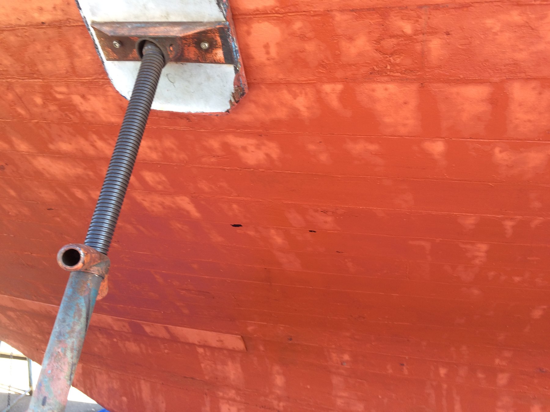 A corroded through-hull fitting and seacock assembly on the classic Merry Maiden's hull reveals the salt-water maintenance challenges of preserving a 1946 wooden yacht in the Pacific Northwest.
