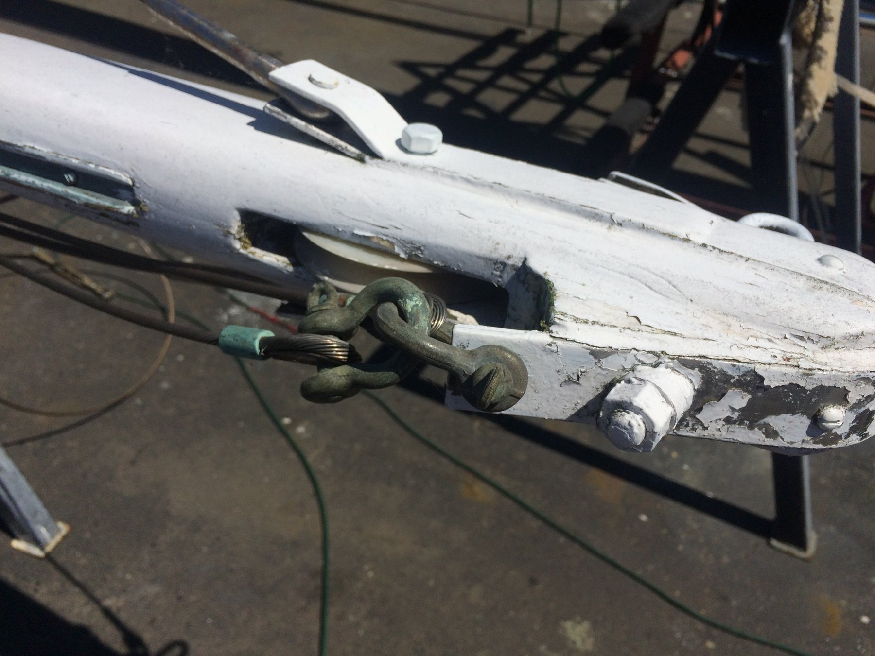 Weathered bronze shackles and corroded hardware on the Merry Maiden's deck speak to decades of salt air and Pacific Northwest sailing, a testament to this classic 1946 yacht's enduring character.