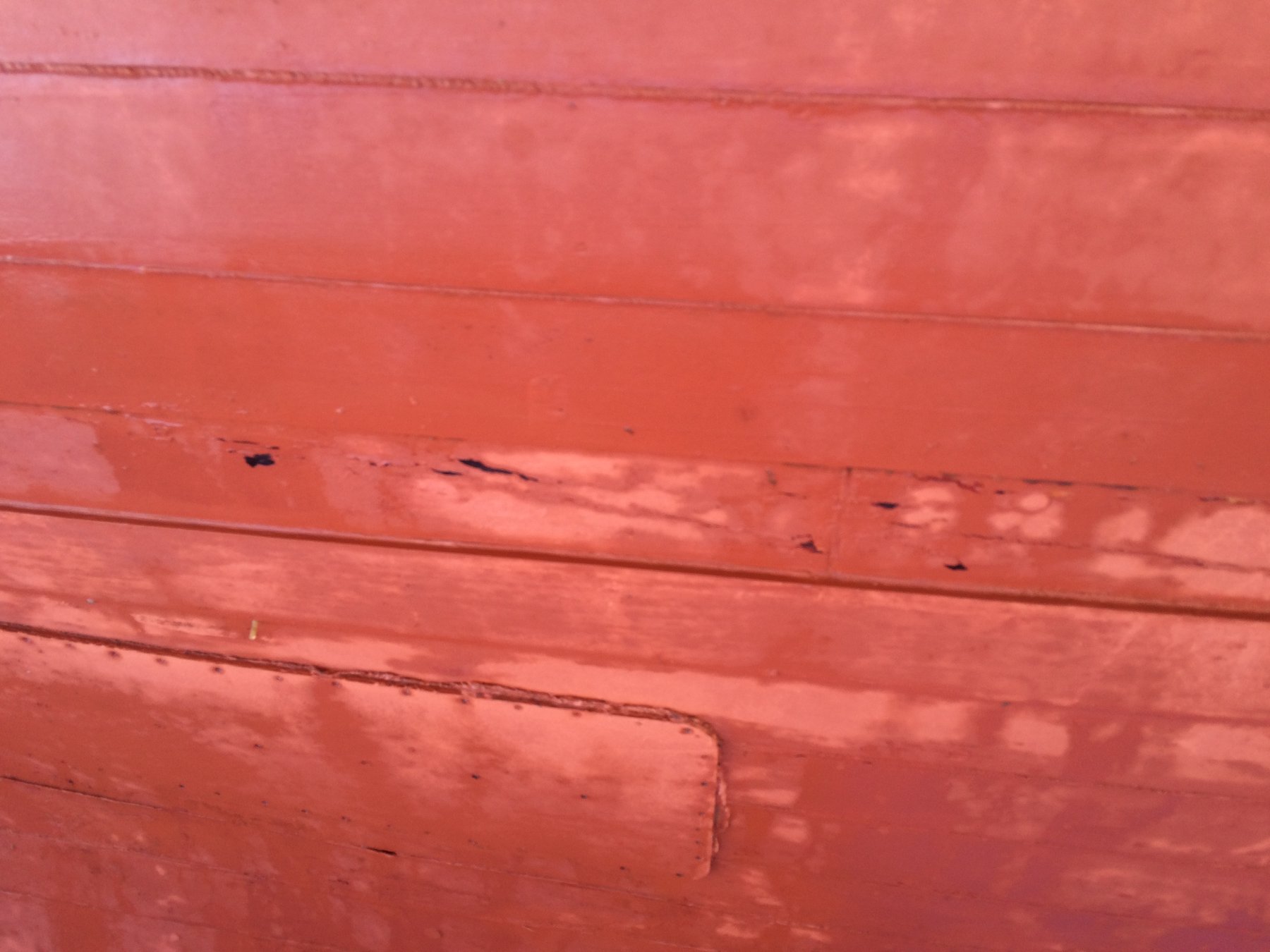 The weathered planking of Merry Maiden's hull reveals the patina of a classic 1946 wooden yacht, with seams and fasteners telling stories of decades on Puget Sound waters.